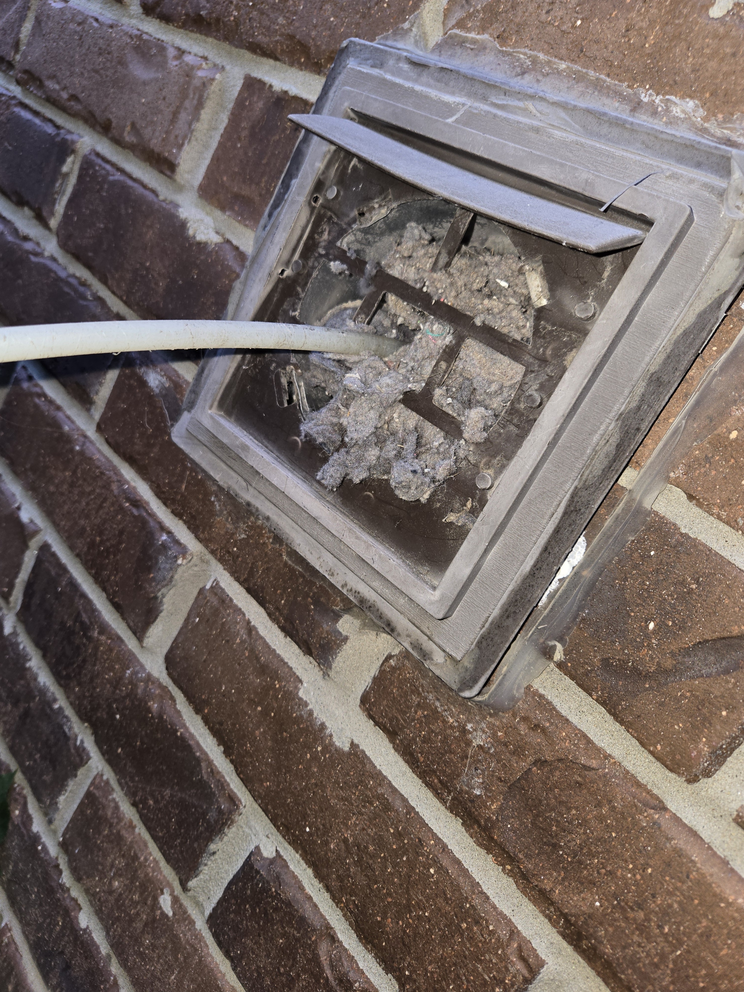 Before: Dirty dryer vent clogged with lint